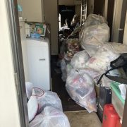 ゴミが積みあがったアパート室内