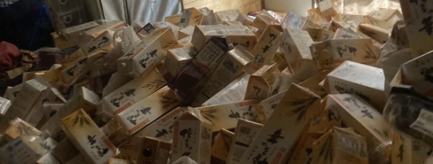 日本酒のパックが大量に積みあがったゴミ部屋
