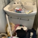 栃木県宇都宮市の洗面所でゴミ屋敷状態となった片付け前の様子。洗面台にはペットボトルや洗剤容器が散乱し、床には衣類やゴミ袋が積み重なって足の踏み場がない状態。