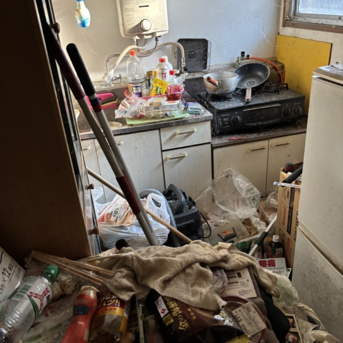 栃木県宇都宮市の賃貸住宅キッチン。床一面に食品残骸やペットボトル、生活ゴミが散乱し、調理台やシンクにも不用品が積み重なったゴミ屋敷の状態。強烈な悪臭と害虫発生のリスクが高い現場。