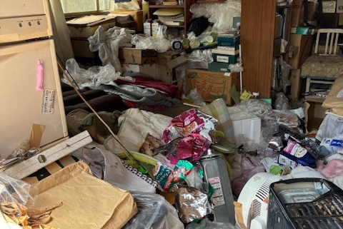 栃木県宇都宮市の4DK空き家室内。生活ゴミや紙類、衣類、日用品、空き容器が床一面に堆積し、生活動線が完全に失われたゴミ屋敷状態。