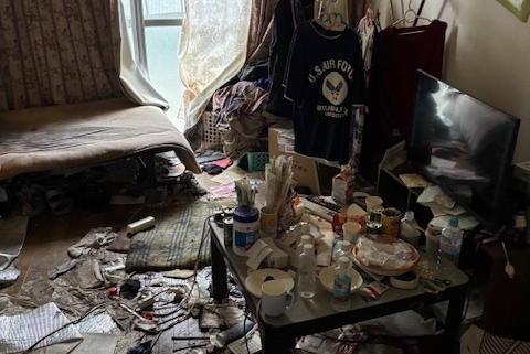 居室内に生活用品や紙類、容器類が床一面に散乱している状態